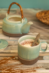 cup milk on wooden table with teapot