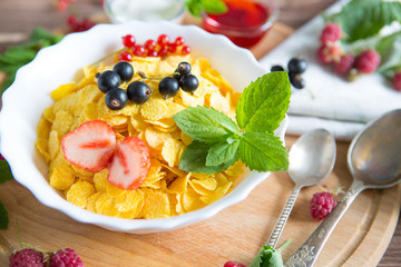 Homemade granola with milk for breakfast top view Healthy tasty breakfast cornflakes with strawberries, raspberries, black currants and red currants.
