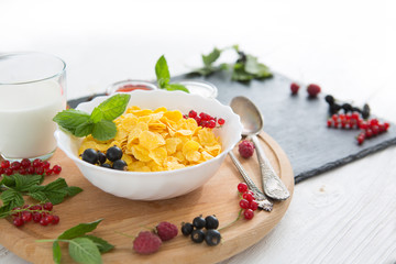 bowl of muesli and yogurt with fresh berries Healthy tasty breakfast cornflakes with strawberries, raspberries, black currants and red currants.