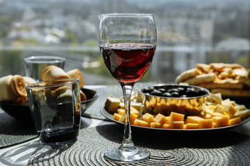 glass of red wine with food on the table