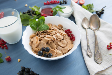 Ingredients tasty healthy breakfast for cooking with milk. Healthy tasty breakfast multigrain wholewheat healthy cereals with strawberries, raspberries, black currants and red currants.
