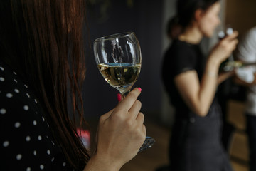 a glass in a girl’s hand with a blurry background