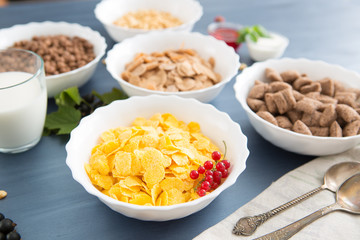 oatmeal with nuts and dried fruits on old white painted wooden table. Perfect breakfast Breakfast cereal mix: cornflakes, pads, muesli, multigrain flakes and chocolate balls