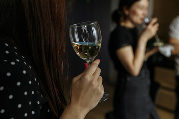 a glass in a girl’s hand with a blurry background