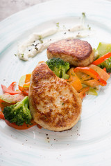 Meat cutlets served with steamed vegetables