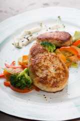 Meat cutlets served with steamed vegetables