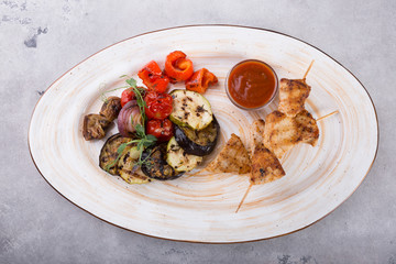Chicken grilled on wooden skewers with vegetables