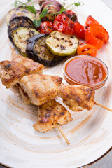 Chicken grilled on wooden skewers with vegetables