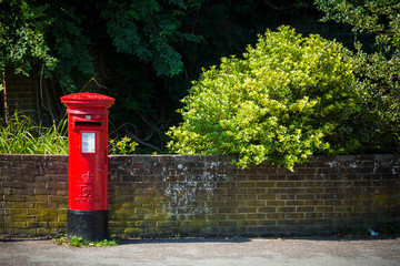 British red postbox in rural street on sunny day