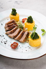 Smoked and sliced duck meat served with polenta