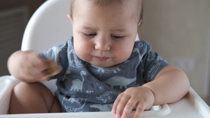 Little baby eating kids homemade cookies himself and smiling. Slow motion