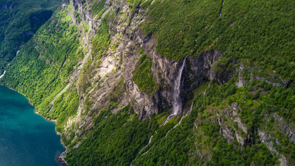 Aerial view of Sunnylvsfjorden fjord canyon, Geiranger village location, western Norway. Aerial evening view of famous Seven Sisters waterfalls. Beauty of nature concept background.