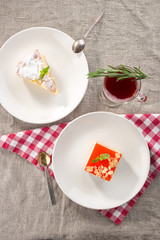 Set of two desserts apple sponge cake and vanilla souffle cake with cranberry tea on grey tablecloth