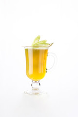 Ginger tea with lemon in a glass mug decorated with celery isolated on white background