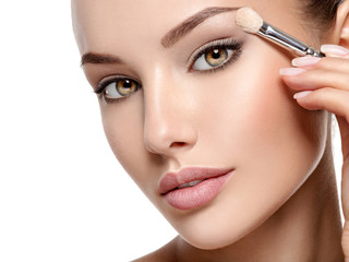 Beautiful woman applying eyeshadow use makeup brush - obrazy, fototapety, plakaty