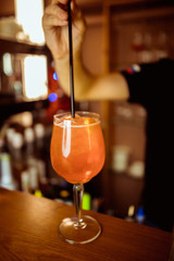 female bartender preparing aperol cocktail in a cocktail bar