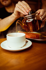 Process brewing tea,tea ceremony,Cup of freshly brewed black tea,warm soft light, darker background.