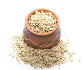 Oats, grain cereal in clay pot isolated on white background