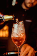 female bartender preparing aperol cocktail in a cocktail bar