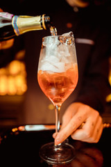 female bartender preparing aperol cocktail in a cocktail bar