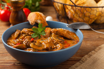 Boeuf, Stroganow, Strogonow. Classic, Russian beef stew.  Served in a blue bowl. Front view. Natural background.