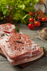 Raw bacon in whole on wooden background.