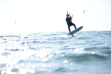 Kite surfer having fun on a beautiful sunny and windy day. Extreme sports and fun. Kitesurfing lessons. Sea and sun. Extreme watersports.