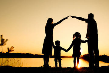 silhouette family, including his father, mother and two children in the hands of