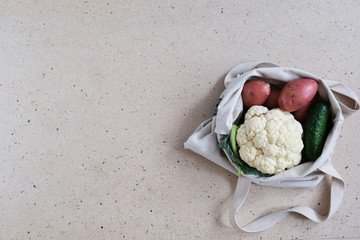 Zero waste food and plastic free shopping concept. Vegetables -  cucumbers, potatoes, cauliflower- in cotton bag.