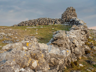 Very old stone fence in Burren National park, Ireland, Cloudy sky, County Clare Ireland.