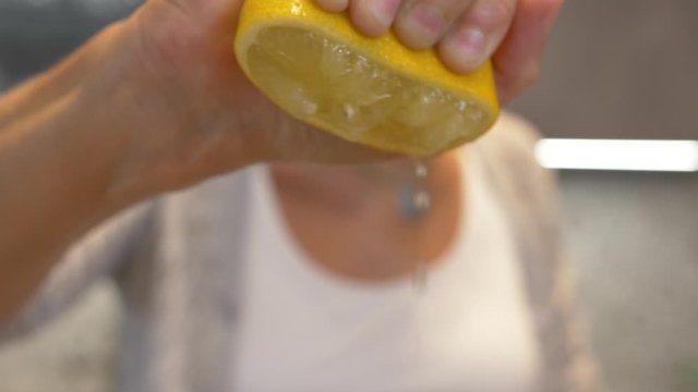 Extreme close-up shot of a hand squeezing a lemon in slow motion