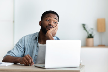 Pensive overworked african american guy dreaming about vacation