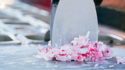 Chef cooking handmade natural asian stir-fried ice cream at freeze pan. Outdoor cooking, gastronomy and street food festival concept