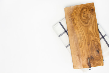 Wooden cutting board from olive tree on checkered towel on white background. Cooking, recipe concept. Top view, flat lay, mock up, copy space