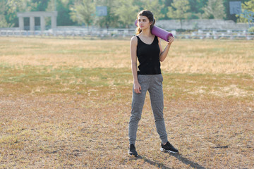 A young slim athletic girl in sportswear with snakeskin prints performs a set of exercises. Fitness...