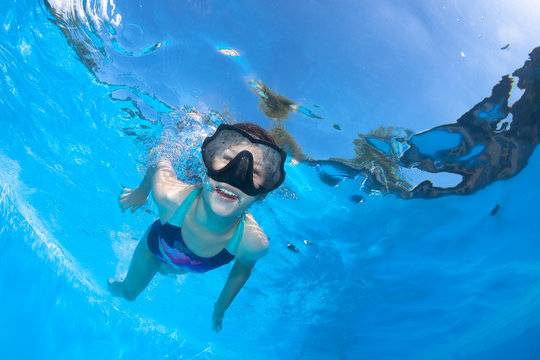 Sporty little girl in a swimsuit swims underwater in the pool . Underwater photography. 