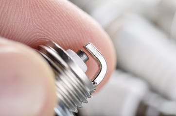 Closeup photo of new spark plug for internal combustion engine in human hand. Space for text