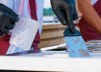 Chef cooking asian natural stir-fried ice cream rolls at freeze pan. Outdoor cooking, gastronomy and street food festival concept