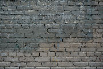 Texture of an old paint covered brick wall. Background image of an abandoned brick wall with painted over paint