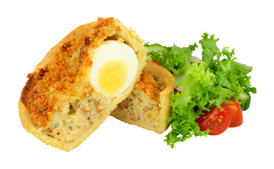 Scotch egg quiche with shortcrust pastry and whole egg encased in pork sausage meat with fresh salad isolated on a white background