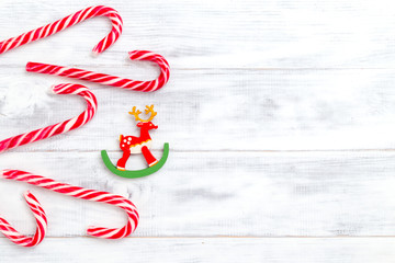 Christmas candy cane and deer on wooden background. Copy space