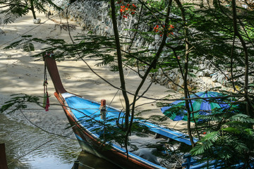 Fototapeta na wymiar 2011.05.07, Phuket, Thailand. Travel around Asia. Boat on the sand by palm trees.