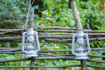 Rustic lanterns hanging on the wooden fence