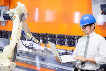 The engineer programming the robotic arms for loading the sheet metal to the hydraulic bending...