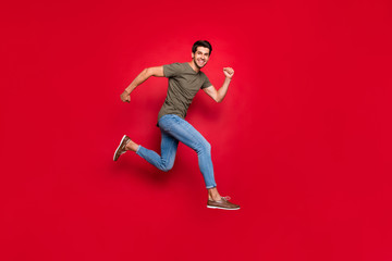 Fototapeta na wymiar Full size photo of champion guy jumping high came first to finish wear casual outfit isolated on red background