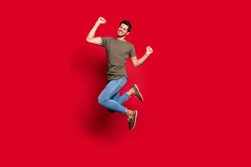 Full length photo of amazing guy jumping high ecstatic win wear casual outfit isolated on red background