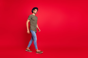 Full size photo of amazing guy walking park wear casual outfit isolated on red background