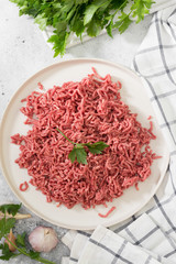 Ground beef on a white plate. Light background