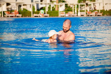 father teaching daughter to swim