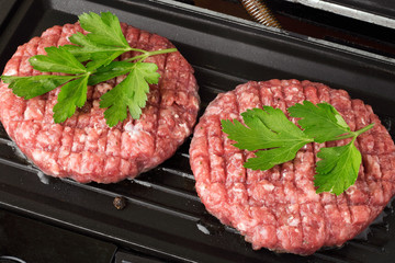 Raw Ground beef meat Burger steak cutlets fried on a hot grill. Cutlet for burger with vegetables and spices. fast food